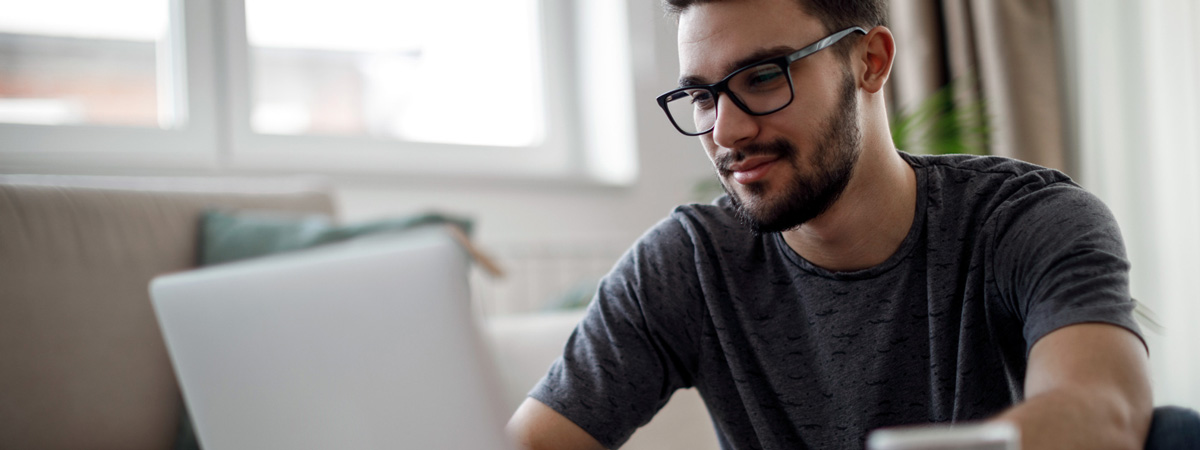 Jeune homme regardant l’écran de son ordinateur portable